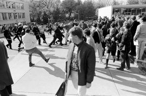 A bystander glances behind him as police officers violently clash with demonstrators during a protest against the Dow Chemical Company on the UW–Madison campus on Oct. 18, 1967