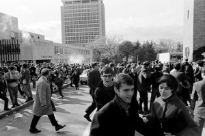 As police release tear gas near the Commerce Building on Oct. 18, 1967, students begin to flee and cover their faces. 